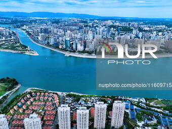 An aerial view shows high-rise buildings lining the riverside city, half landscape and half city, in Yichang, Hubei, China, on September 21,...