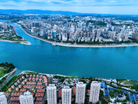 An aerial view shows high-rise buildings lining the riverside city, half landscape and half city, in Yichang, Hubei, China, on September 21,...