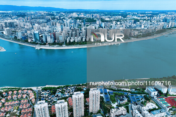 An aerial view shows high-rise buildings lining the riverside city, half landscape and half city, in Yichang, Hubei, China, on September 21,...