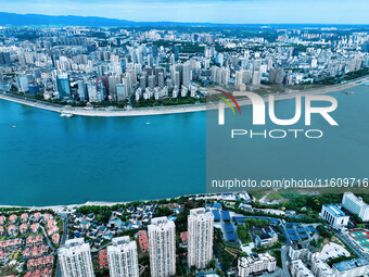 An aerial view shows high-rise buildings lining the riverside city, half landscape and half city, in Yichang, Hubei, China, on September 21,...