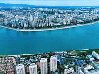 An aerial view shows high-rise buildings lining the riverside city, half landscape and half city, in Yichang, Hubei, China, on September 21,...