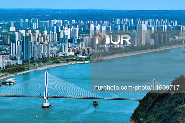 An aerial view shows high-rise buildings lining the riverside city, half landscape and half city, in Yichang, Hubei, China, on September 21,...