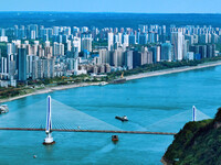 An aerial view shows high-rise buildings lining the riverside city, half landscape and half city, in Yichang, Hubei, China, on September 21,...