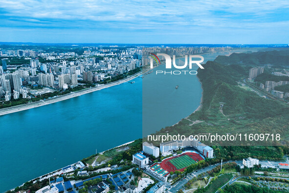 An aerial view shows high-rise buildings lining the riverside city, half landscape and half city, in Yichang, Hubei, China, on September 21,...