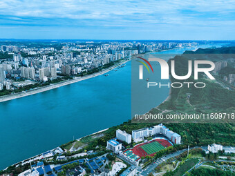 An aerial view shows high-rise buildings lining the riverside city, half landscape and half city, in Yichang, Hubei, China, on September 21,...