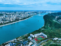 An aerial view shows high-rise buildings lining the riverside city, half landscape and half city, in Yichang, Hubei, China, on September 21,...