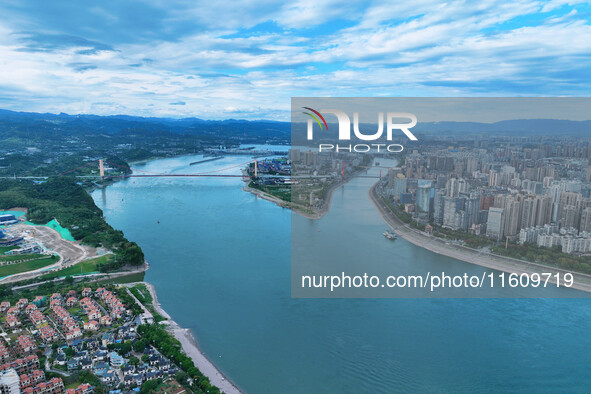 An aerial view shows high-rise buildings lining the riverside city, half landscape and half city, in Yichang, Hubei, China, on September 21,...