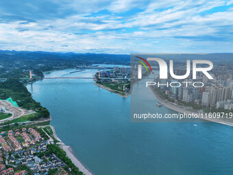 An aerial view shows high-rise buildings lining the riverside city, half landscape and half city, in Yichang, Hubei, China, on September 21,...