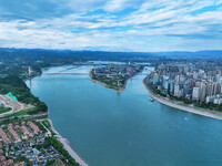 An aerial view shows high-rise buildings lining the riverside city, half landscape and half city, in Yichang, Hubei, China, on September 21,...