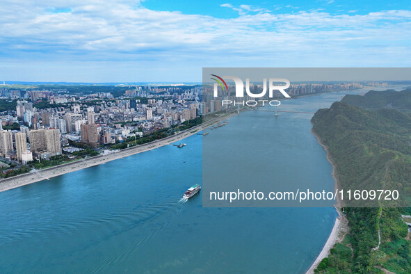 An aerial view shows high-rise buildings lining the riverside city, half landscape and half city, in Yichang, Hubei, China, on September 21,...