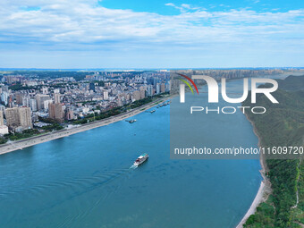 An aerial view shows high-rise buildings lining the riverside city, half landscape and half city, in Yichang, Hubei, China, on September 21,...