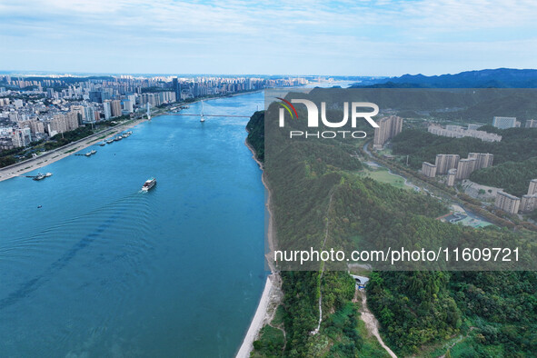 An aerial view shows high-rise buildings lining the riverside city, half landscape and half city, in Yichang, Hubei, China, on September 21,...