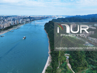 An aerial view shows high-rise buildings lining the riverside city, half landscape and half city, in Yichang, Hubei, China, on September 21,...