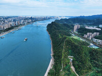 An aerial view shows high-rise buildings lining the riverside city, half landscape and half city, in Yichang, Hubei, China, on September 21,...