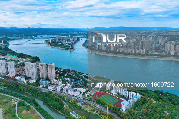 An aerial view shows high-rise buildings lining the riverside city, half landscape and half city, in Yichang, Hubei, China, on September 21,...