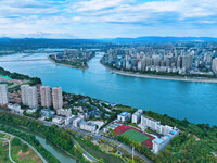 An aerial view shows high-rise buildings lining the riverside city, half landscape and half city, in Yichang, Hubei, China, on September 21,...