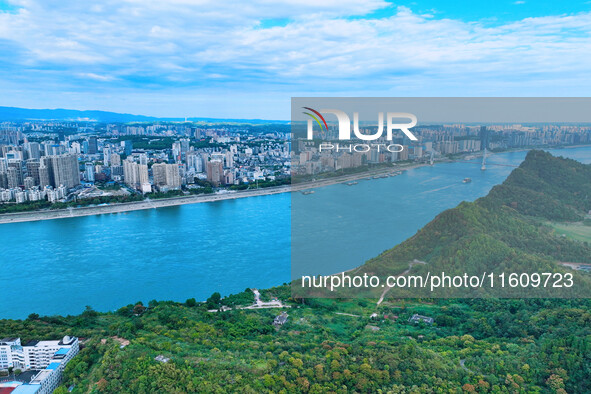 An aerial view shows high-rise buildings lining the riverside city, half landscape and half city, in Yichang, Hubei, China, on September 21,...