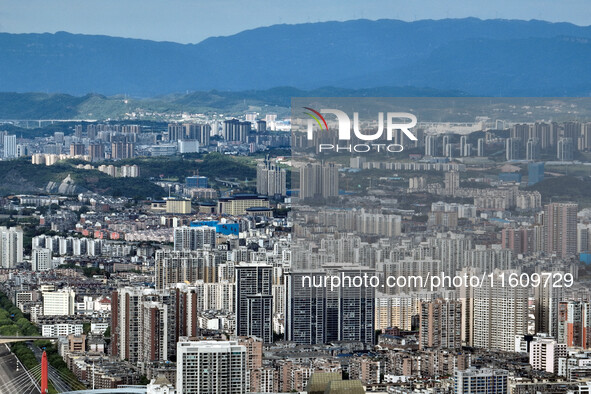 An aerial view shows high-rise buildings lining the riverside city in Yichang, Hubei, China, on September 21, 2024. 