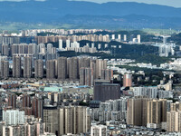 An aerial view shows high-rise buildings lining the riverside city in Yichang, Hubei, China, on September 21, 2024. (