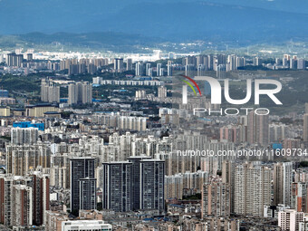 An aerial view shows high-rise buildings lining the riverside city in Yichang, Hubei, China, on September 21, 2024. (