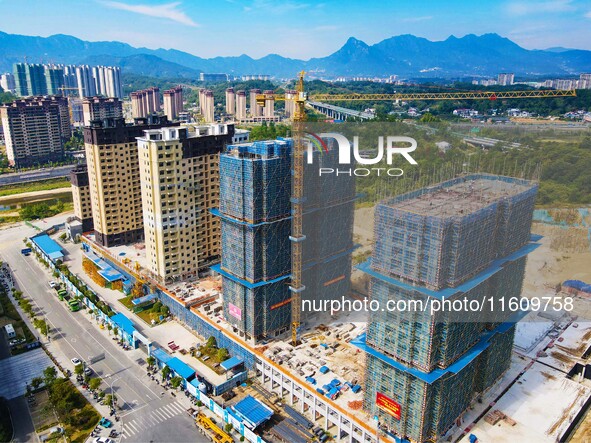 Builders step up construction at the construction site of the Zaofan resettlement area in Yuexi County, Anqing, China, on September 25, 2024...