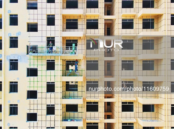 Builders step up construction at the construction site of the Zaofan resettlement area in Yuexi County, Anqing, China, on September 25, 2024...