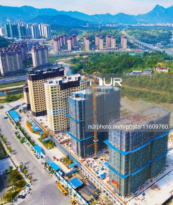 Builders step up construction at the construction site of the Zaofan resettlement area in Yuexi County, Anqing, China, on September 25, 2024...