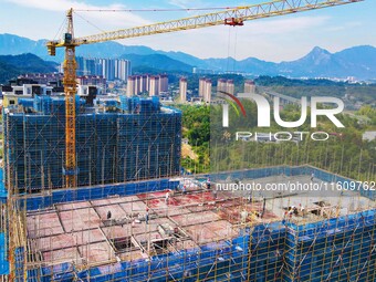 Builders step up construction at the construction site of the Zaofan resettlement area in Yuexi County, Anqing, China, on September 25, 2024...