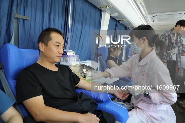 Primary school teachers donate blood on a mobile blood collection vehicle in Yancheng, China, on September 26, 2024. 