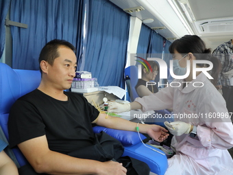 Primary school teachers donate blood on a mobile blood collection vehicle in Yancheng, China, on September 26, 2024. (