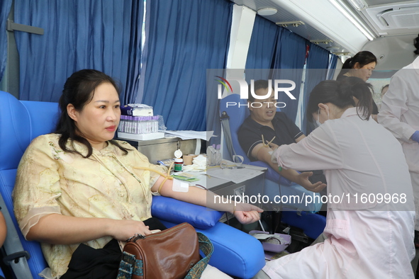 Primary school teachers donate blood on a mobile blood collection vehicle in Yancheng, China, on September 26, 2024. 