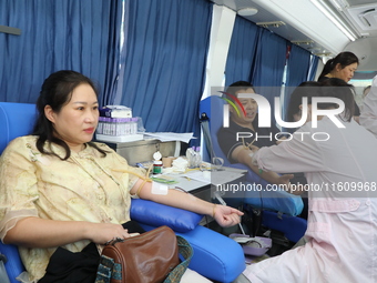 Primary school teachers donate blood on a mobile blood collection vehicle in Yancheng, China, on September 26, 2024. (