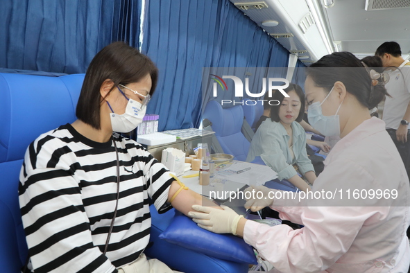 Primary school teachers donate blood on a mobile blood collection vehicle in Yancheng, China, on September 26, 2024. 