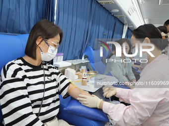 Primary school teachers donate blood on a mobile blood collection vehicle in Yancheng, China, on September 26, 2024. (