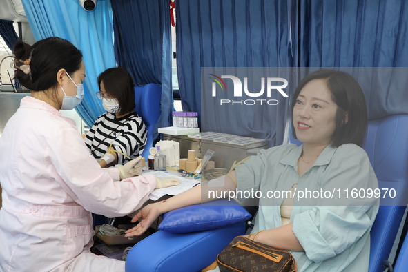 Primary school teachers donate blood on a mobile blood collection vehicle in Yancheng, China, on September 26, 2024. 