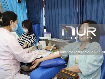 Primary school teachers donate blood on a mobile blood collection vehicle in Yancheng, China, on September 26, 2024. (