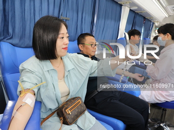 Primary school teachers donate blood on a mobile blood collection vehicle in Yancheng, China, on September 26, 2024. (