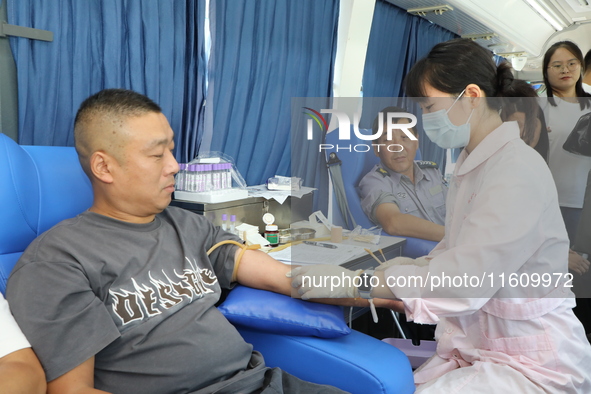 Primary school teachers donate blood on a mobile blood collection vehicle in Yancheng, China, on September 26, 2024. 