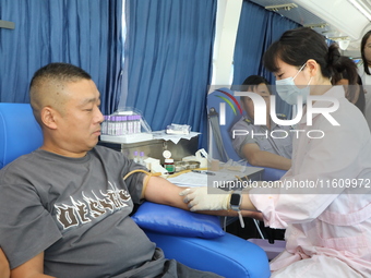 Primary school teachers donate blood on a mobile blood collection vehicle in Yancheng, China, on September 26, 2024. (