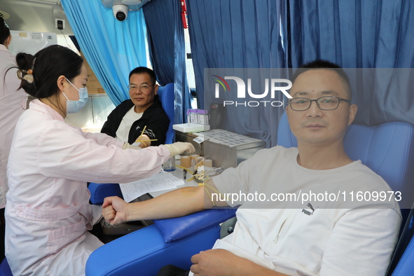 Primary school teachers donate blood on a mobile blood collection vehicle in Yancheng, China, on September 26, 2024. 