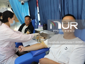 Primary school teachers donate blood on a mobile blood collection vehicle in Yancheng, China, on September 26, 2024. (