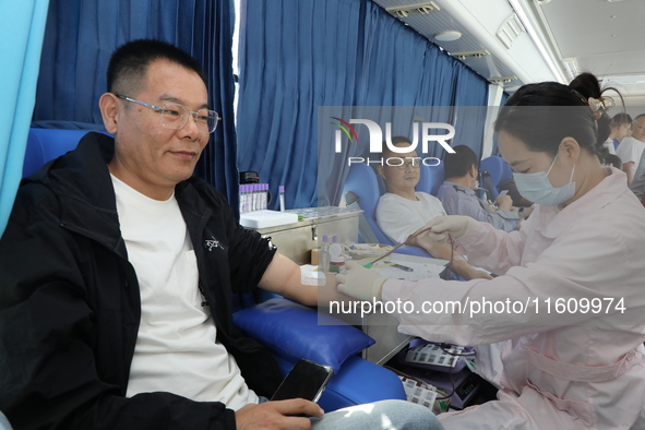 Primary school teachers donate blood on a mobile blood collection vehicle in Yancheng, China, on September 26, 2024. 