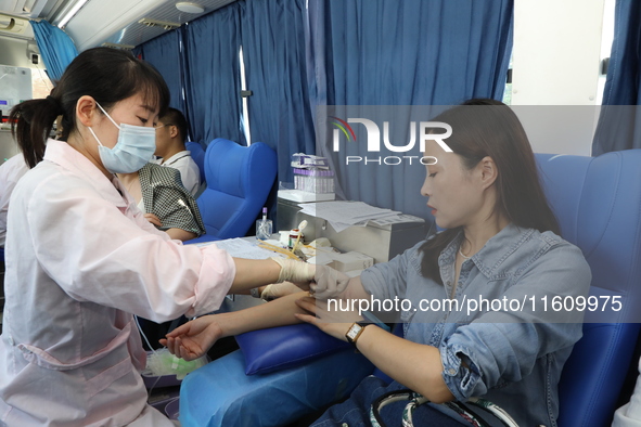 Primary school teachers donate blood on a mobile blood collection vehicle in Yancheng, China, on September 26, 2024. 