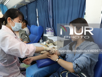 Primary school teachers donate blood on a mobile blood collection vehicle in Yancheng, China, on September 26, 2024. (