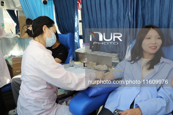 Primary school teachers donate blood on a mobile blood collection vehicle in Yancheng, China, on September 26, 2024. 