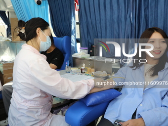 Primary school teachers donate blood on a mobile blood collection vehicle in Yancheng, China, on September 26, 2024. (