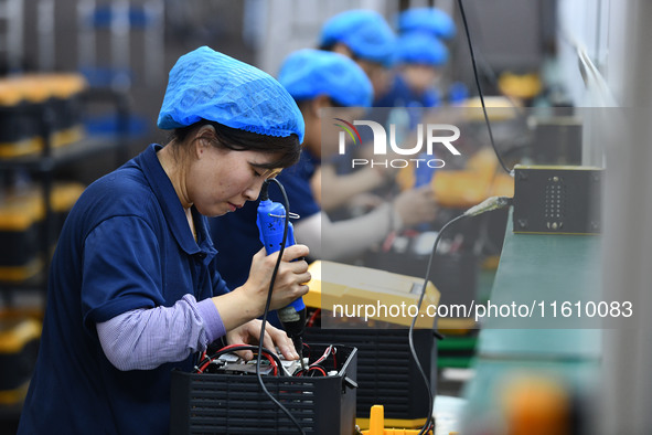 Workers work at a mobile energy storage power production workshop of an electric company in Fuyang, China, on September 26, 2024. 