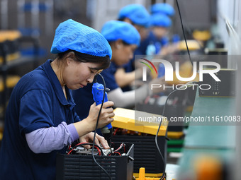 Workers work at a mobile energy storage power production workshop of an electric company in Fuyang, China, on September 26, 2024. (