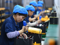 Workers work at a mobile energy storage power production workshop of an electric company in Fuyang, China, on September 26, 2024. (