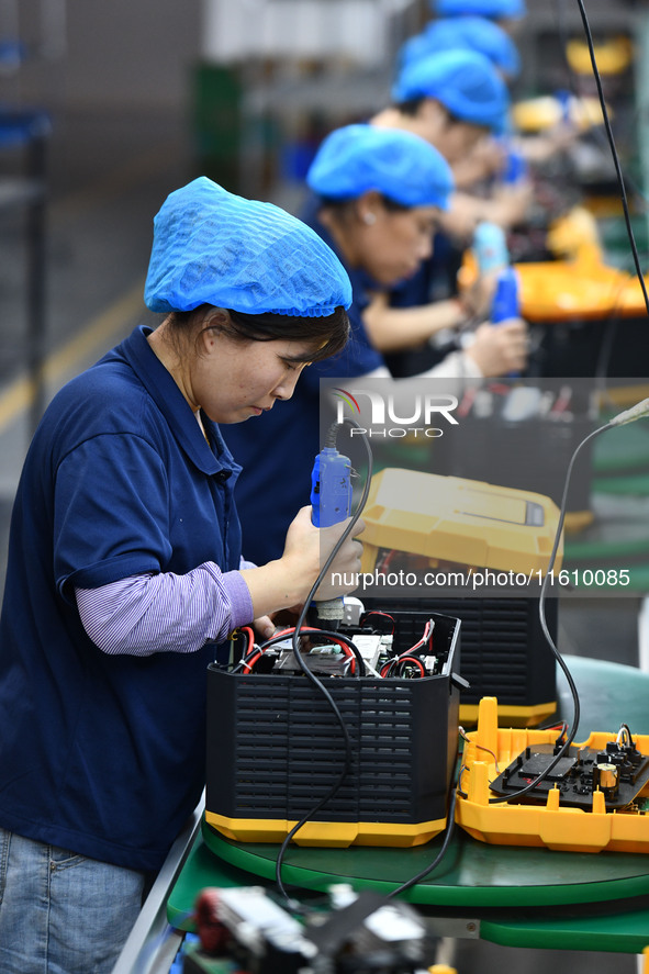 Workers work at a mobile energy storage power production workshop of an electric company in Fuyang, China, on September 26, 2024. 